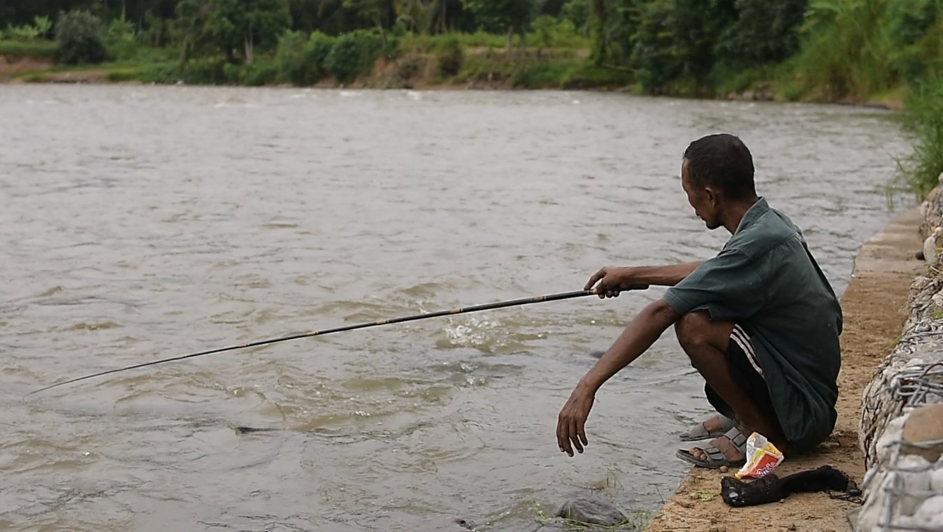 Warga yang sedang mancing dipinggir sungai