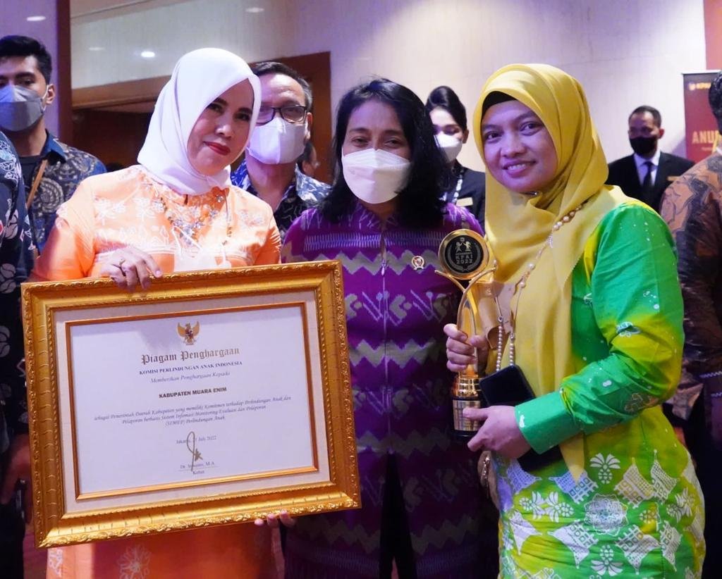 Kepala Dinas PPPA Muara Enim Memegang Piala KPAI 2022