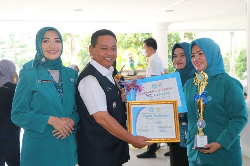 Pj. Bupati Kurniawan membagikan sertifikat dan tropy penghargaan kepada pemenang lomba peringatan HKG PKK