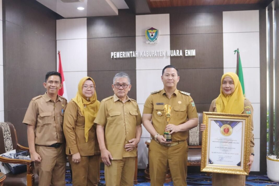 Pj. Bupati Muara Enim, H. Henky Putrawan, S.Pt., M.Si., M.M., menerima piala dan piagam dari Kepala Balitbangda Muara Enim, Panca Surya Dihata, S.H., M.H. didampingi Kepala Bidang Inovasi dan Teknologi Balibangda Ester Claudya Damayanti, S.T., M.Eng., dan Anggraini Wulan Pratiwi, S.Sn. dan Efran Fauzan,SE